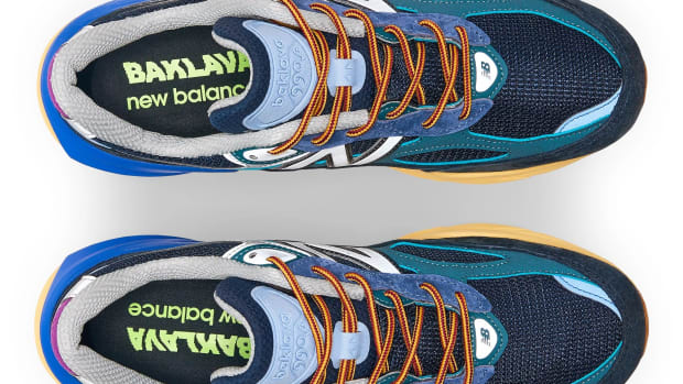 View of blue and orange New Balance shoes.